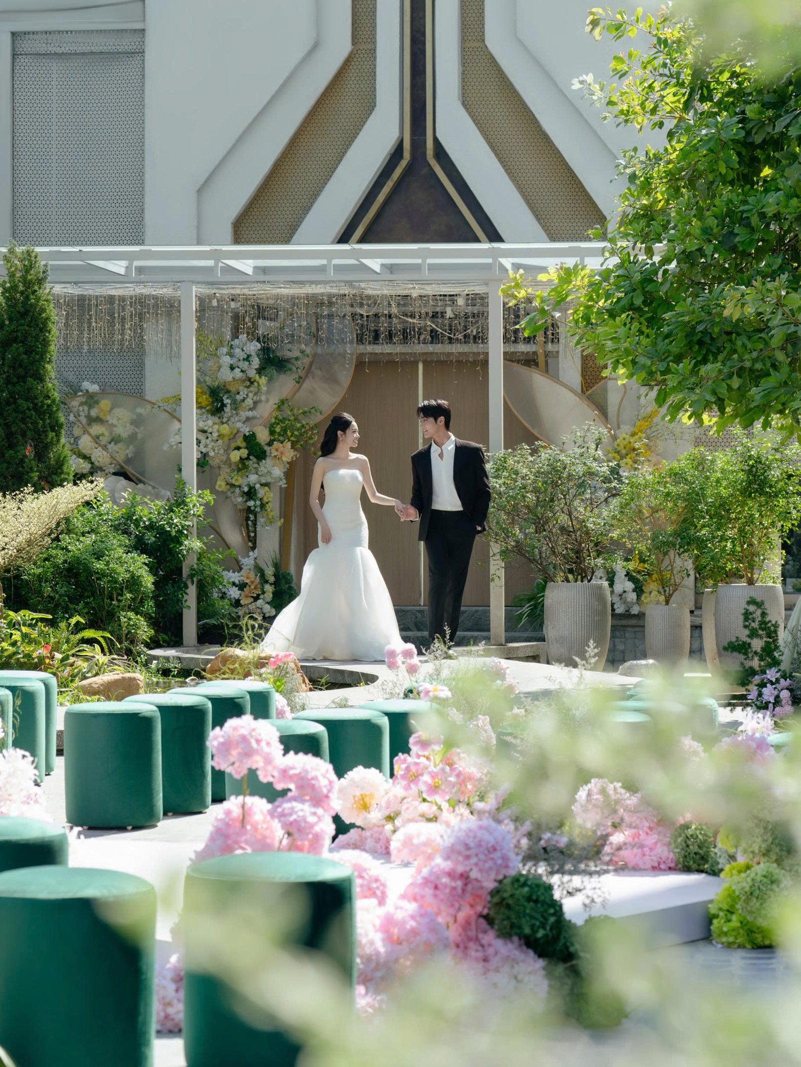 Cô dâu chú rể trong khu vườn trước mặt tiền Trống Đồng Palace