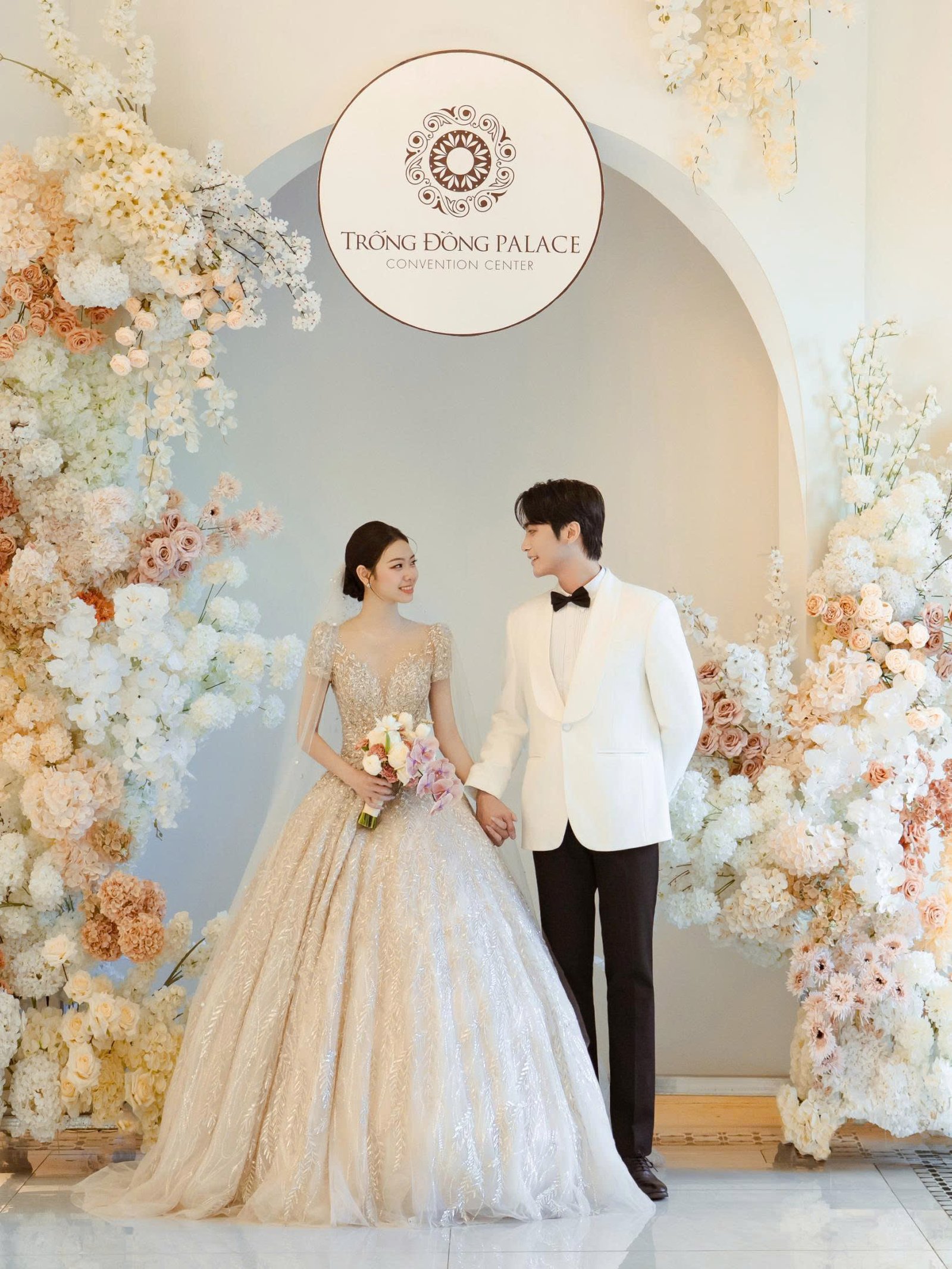 Cô dâu chú rể tại sảnh đón tiếp với biểu tượng Trống Đồng Palace